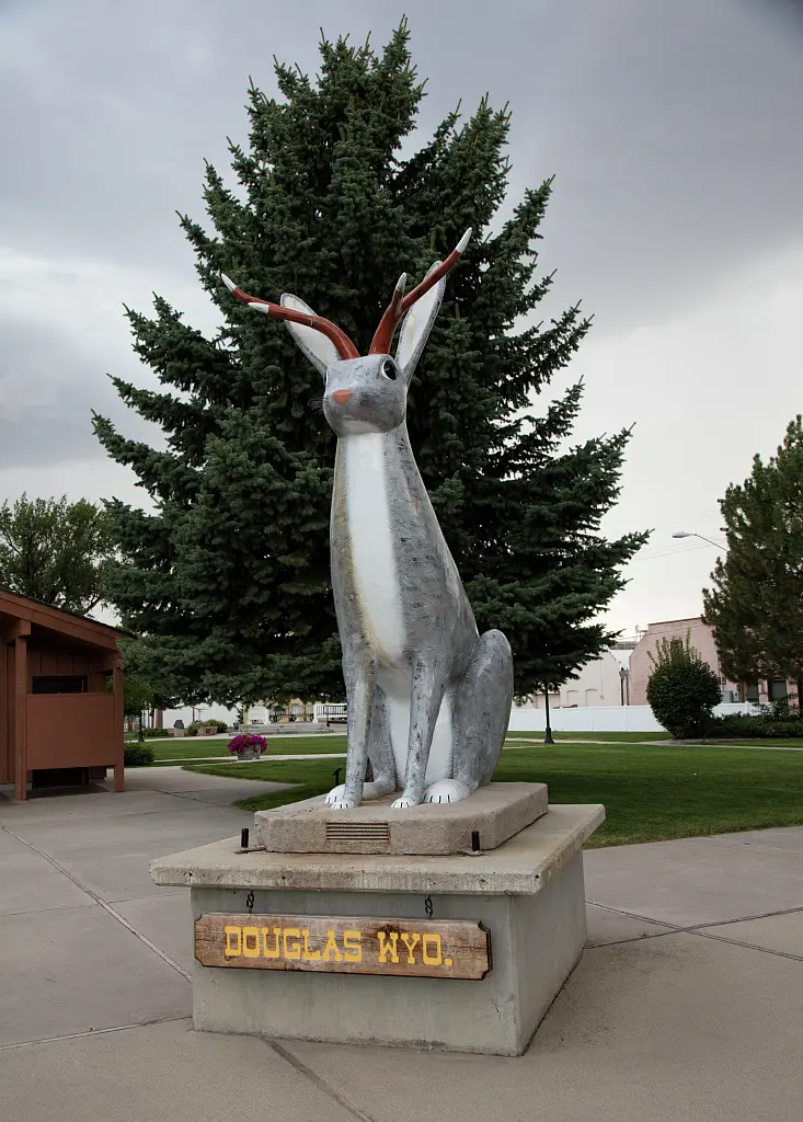 Large white jackalope statue with red eyes standing in Douglas, Wyoming